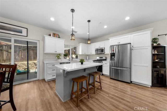 717 Lingel Dr, El Cajon, CA 92019 - kitchen with stainless steel appliances, light countertops, light wood-style floors, white cabinets, and a kitchen island