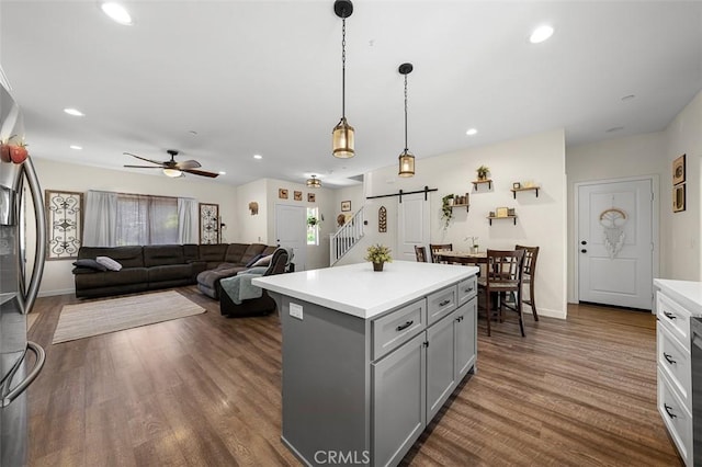717 Lingel Dr, El Cajon, CA 92019 - kitchen with gray cabinetry, a barn door, light countertops, dark wood finished floors, and a kitchen island