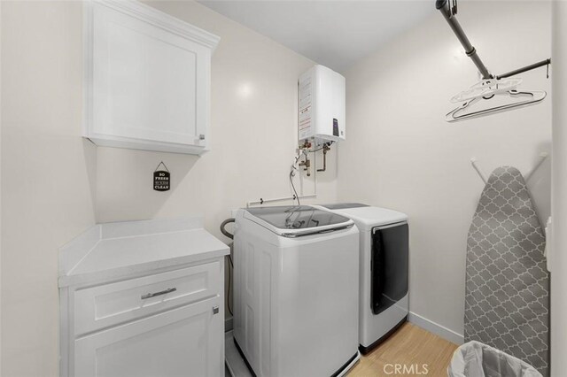 717 Lingel Dr, El Cajon, CA 92019 - laundry room with tankless water heater, separate washer and dryer, light wood-style floors, and cabinet space