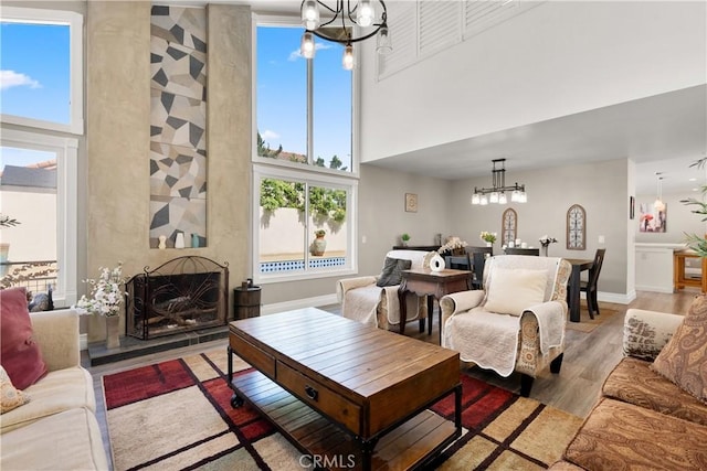 2040 Cape Cod Ct, Claremont, CA 91711 - living room featuring a chandelier, a high ceiling, healthy amount of natural light, and light wood-style flooring