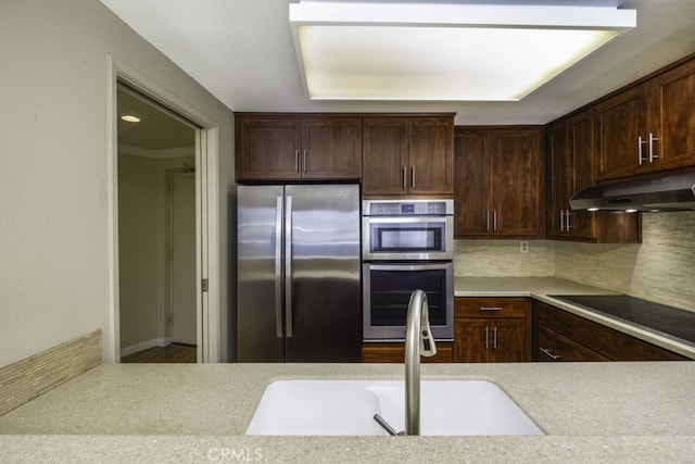 700 E Ocean Blvd Unit 2606, Long Beach, CA 90802 - kitchen featuring appliances with stainless steel finishes, under cabinet range hood, light countertops, decorative backsplash, and dark brown cabinets
