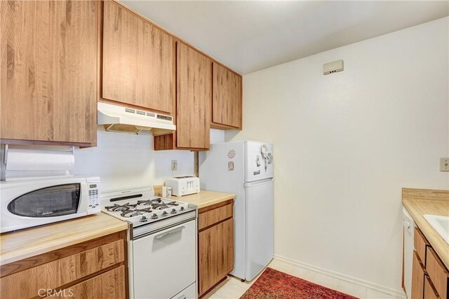 4565 Alamo St Unit H, Simi Valley, CA 93063 - kitchen with under cabinet range hood, white appliances, light countertops, and light tile patterned floors