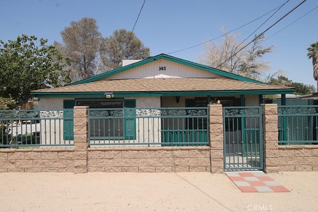 38103 Dividing Line St, Yermo, CA 92398 - view of front of home featuring roof with shingles, a fenced front yard, stucco siding, and a porch