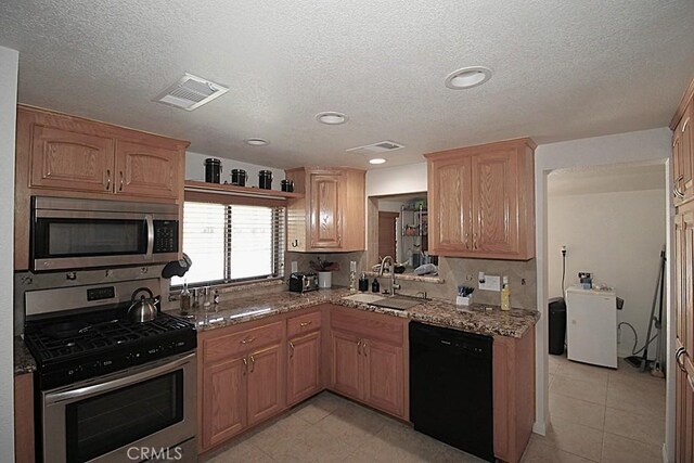 38103 Dividing Line St, Yermo, CA 92398 - kitchen with stainless steel appliances, light stone countertops, a textured ceiling, light tile patterned floors, and recessed lighting