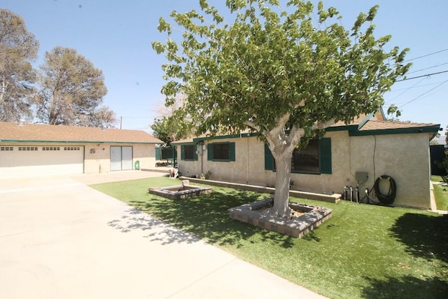 38103 Dividing Line St, Yermo, CA 92398 - view of front of house featuring stucco siding, concrete driveway, a front lawn, and an attached garage