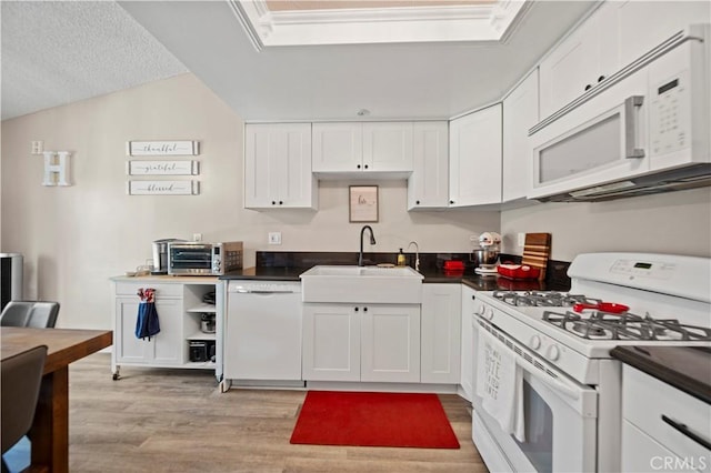 28927 Rue Daniel Cyn, Country, CA 91387 - kitchen with white appliances, dark countertops, white cabinets, and light wood finished floors