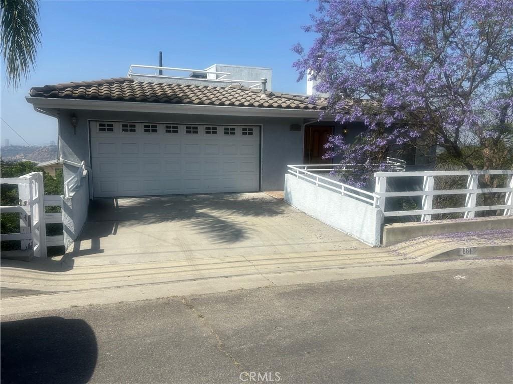 881 Mount Washington Dr, Los Angeles, CA 90065 - view of front facade featuring a tile roof, concrete driveway, an attached garage, and stucco siding