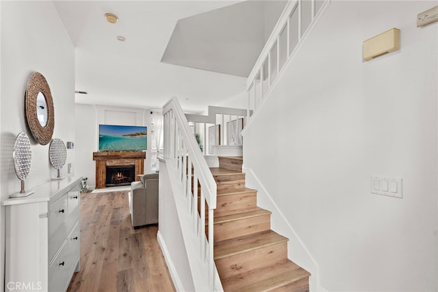 36 Via Madera, Rancho Santa Margarita, CA 92688 - staircase with a lit fireplace and wood finished floors