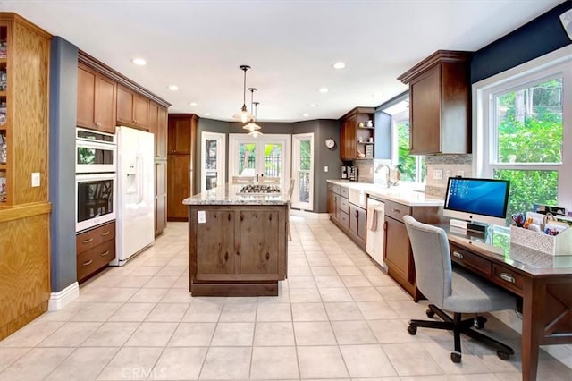 26181 San Marino Ct, Mission Viejo, CA 92692 - kitchen featuring stainless steel appliances, open shelves, a center island, a desk, and light tile patterned floors