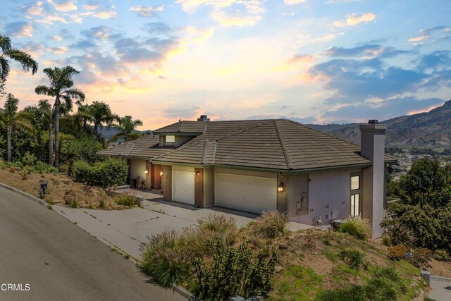 800 Manor Ridge Rd, Santa Paula, CA 93060 - view of front facade featuring a chimney, concrete driveway, an attached garage, a tile roof, and stucco siding