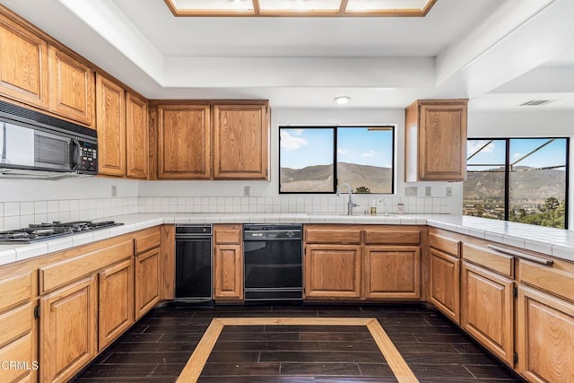 800 Manor Ridge Rd, Santa Paula, CA 93060 - kitchen featuring black appliances, a tray ceiling, dark wood-type flooring, and tile countertops