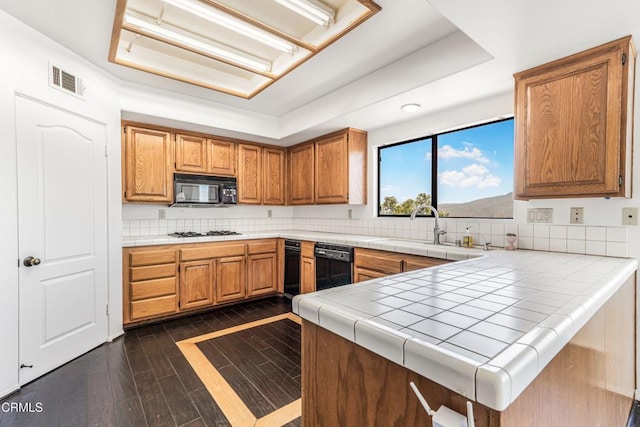 800 Manor Ridge Rd, Santa Paula, CA 93060 - kitchen with a tray ceiling, black appliances, dark wood-style floors, tile countertops, and decorative backsplash