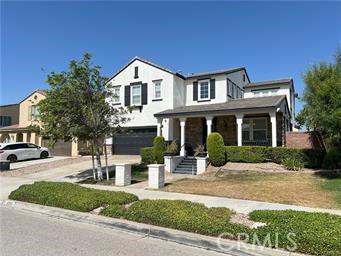 4866 Stoneglen Ave, Fontana, CA 92336 - view of front of home with a garage, a porch, and concrete driveway