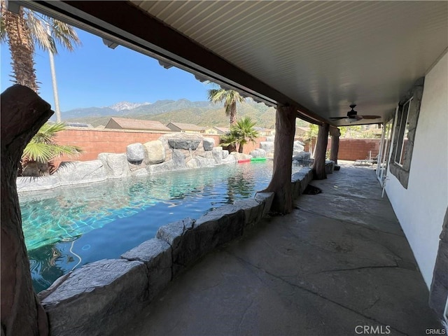 4866 Stoneglen Ave, Fontana, CA 92336 - fenced backyard featuring a mountain view, an outdoor pool, a ceiling fan, and a patio area
