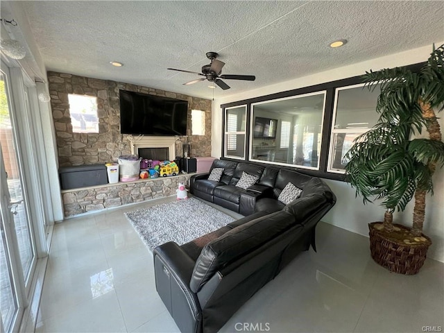 4866 Stoneglen Ave, Fontana, CA 92336 - living room featuring an outdoor stone fireplace, a ceiling fan, a textured ceiling, and tile patterned floors