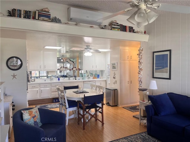 1271 Kenwood Rd Unit M7-J, Seal Beach, CA 90740 - dining space with an AC wall unit, a ceiling fan, and light wood-style flooring