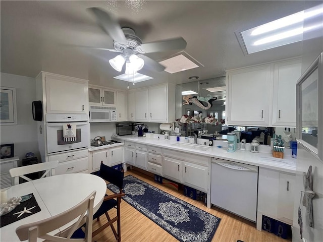 1271 Kenwood Rd Unit M7-J, Seal Beach, CA 90740 - kitchen featuring white appliances, white cabinets, ceiling fan, light wood finished floors, and light countertops
