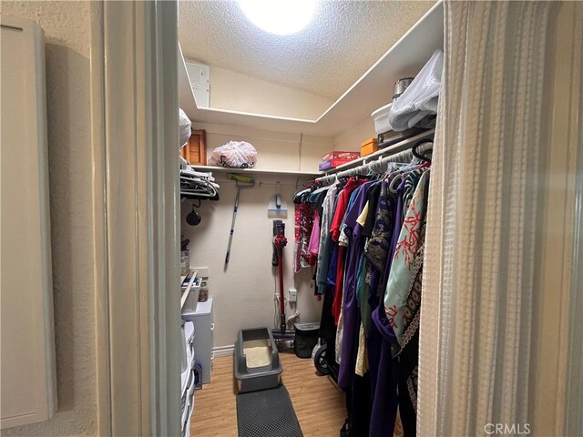 1271 Kenwood Rd Unit M7-J, Seal Beach, CA 90740 - walk in closet with wood finished floors, independent washer and dryer, and vaulted ceiling