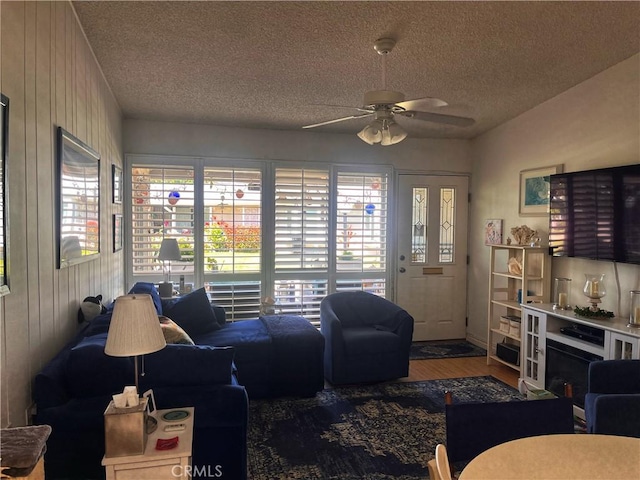 1271 Kenwood Rd Unit M7-J, Seal Beach, CA 90740 - living area featuring ceiling fan, a textured ceiling, wood finished floors, and wood walls