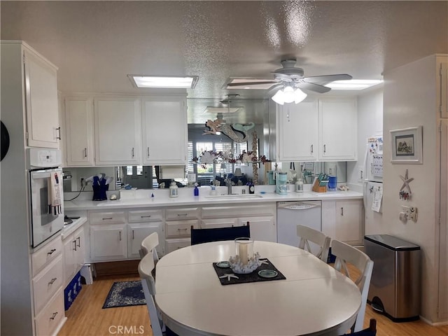 1271 Kenwood Rd Unit M7-J, Seal Beach, CA 90740 - kitchen featuring white appliances, white cabinetry, a ceiling fan, light wood-style floors, and a textured ceiling
