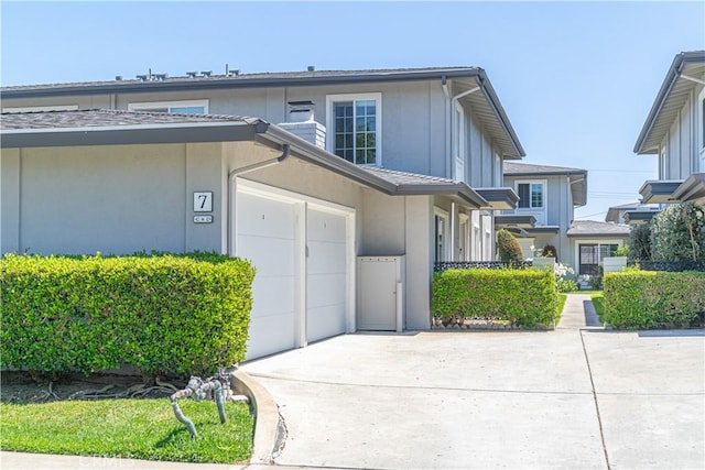 1845 Anaheim Ave Unit 27, Costa Mesa, CA 92627 - view of front facade with concrete driveway, a garage, and stucco siding