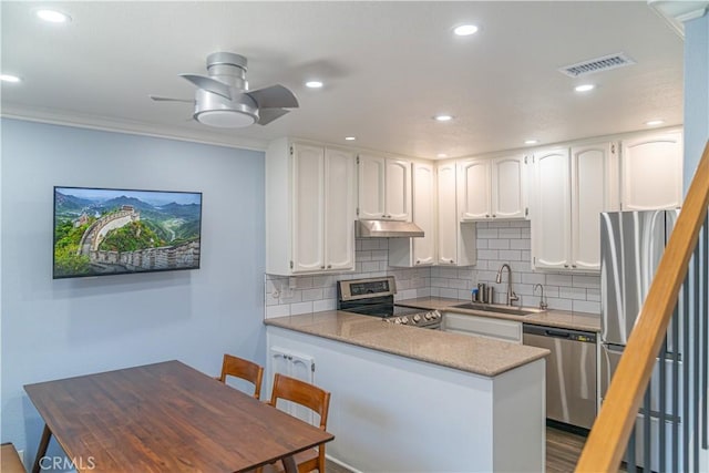 1845 Anaheim Ave Unit 27, Costa Mesa, CA 92627 - kitchen with stainless steel appliances, under cabinet range hood, a peninsula, white cabinetry, and tasteful backsplash