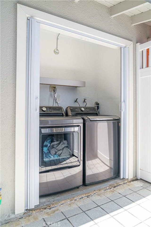 1845 Anaheim Ave Unit 7D, Costa Mesa, CA 92627 - washroom featuring separate washer and dryer and a textured wall