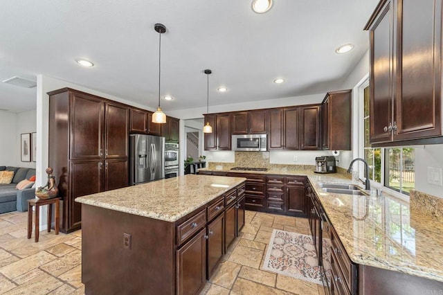 27792 Elderberry St, Murrieta, CA 92562 - kitchen featuring appliances with stainless steel finishes, stone tile flooring, a center island, light stone countertops, and recessed lighting
