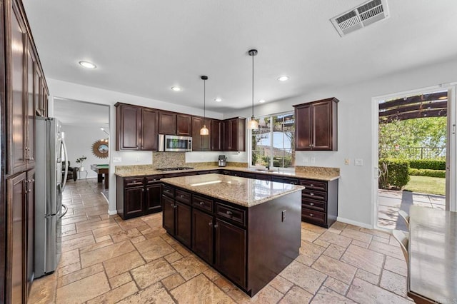 27792 Elderberry St, Murrieta, CA 92562 - kitchen featuring appliances with stainless steel finishes, stone tile flooring, recessed lighting, a center island, and dark brown cabinets