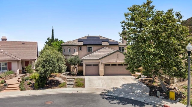 27792 Elderberry St, Murrieta, CA 92562 - view of front of house featuring an attached garage, stucco siding, roof mounted solar panels, and driveway