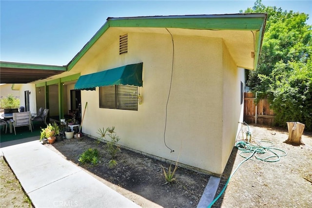 1200 Oxford Way, Hanford, CA 93230 - view of side of home featuring stucco siding and a patio
