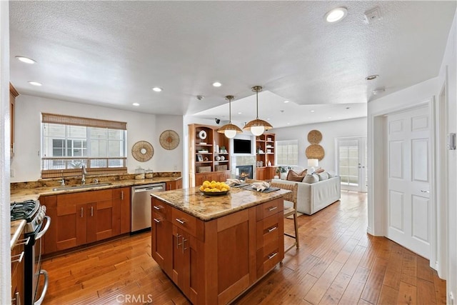 1114 Vincent St Unit A, Redondo Beach, CA 90277 - kitchen with stainless steel appliances, a kitchen island, brown cabinets, light stone counters, and open floor plan