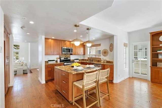 1114 Vincent St Unit A, Redondo Beach, CA 90277 - kitchen featuring stainless steel appliances, light wood-style floors, a kitchen breakfast bar, light stone counters, and recessed lighting