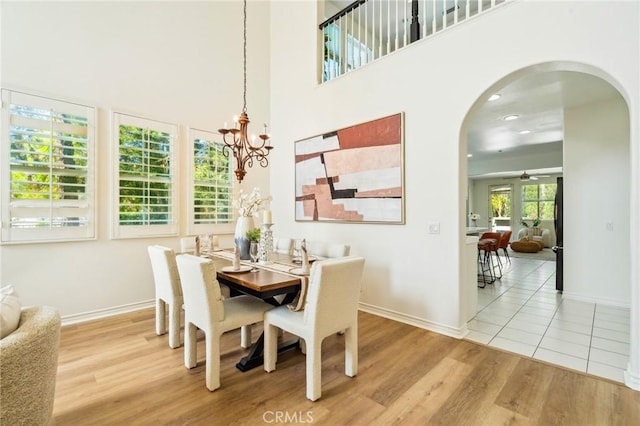 501 Newman Cir, Placentia, CA 92870 - dining area featuring arched walkways, wood finished floors, a chandelier, and a high ceiling