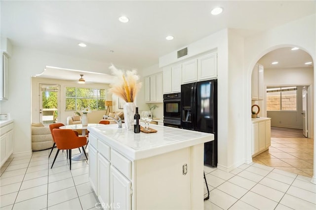 501 Newman Cir, Placentia, CA 92870 - kitchen with tile countertops, black refrigerator with ice dispenser, light tile patterned floors, arched walkways, and open floor plan