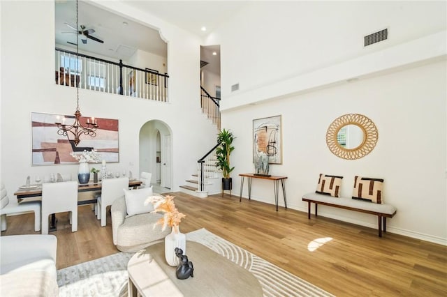 501 Newman Cir, Placentia, CA 92870 - living area with arched walkways, stairway, wood finished floors, a chandelier, and a high ceiling