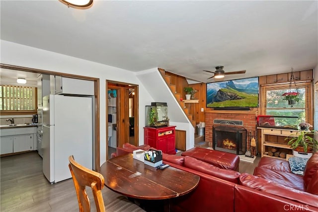 316 La Casita Dr, Twin Peaks, CA 92391 - living room with ceiling fan, light wood finished floors, stairway, and a fireplace
