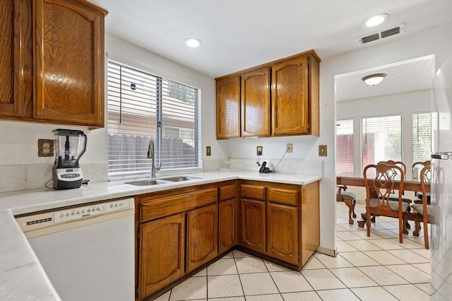 4068 De La Vina Way, Sacramento, CA 95823 - kitchen with dishwasher, brown cabinets, light countertops, light tile patterned floors, and recessed lighting
