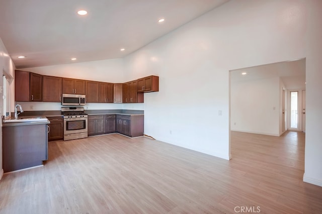 9063 Rosecrest Ln, Fontana, CA 92335 - kitchen with stainless steel appliances, recessed lighting, light wood-type flooring, high vaulted ceiling, and brown cabinetry