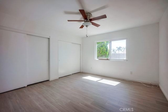 9063 Rosecrest Ln, Fontana, CA 92335 - unfurnished bedroom featuring two closets, wood finished floors, and ceiling fan