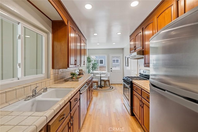 2781 Vuelta Grande Ave, Long Beach, CA 90815 - kitchen with stainless steel appliances, tile countertops, under cabinet range hood, light wood-type flooring, and recessed lighting
