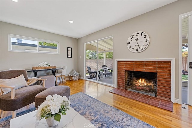 2781 Vuelta Grande Ave, Long Beach, CA 90815 - living room featuring healthy amount of natural light, wood finished floors, a tiled fireplace, and recessed lighting