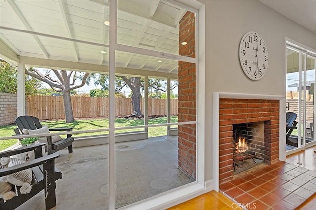 2781 Vuelta Grande Ave, Long Beach, CA 90815 - unfurnished sunroom featuring an outdoor brick fireplace and beam ceiling
