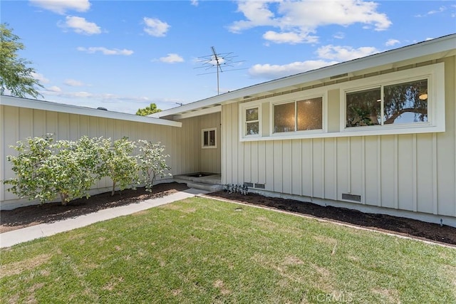 2781 Vuelta Grande Ave, Long Beach, CA 90815 - view of exterior entry with a lawn and board and batten siding
