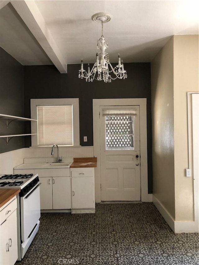 1029 Salem St, Chico, CA 95928 - kitchen with a chandelier, butcher block counters, white cabinetry, white gas range oven, and beamed ceiling
