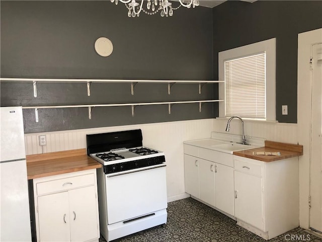 1029 Salem St, Chico, CA 95928 - kitchen featuring white appliances, open shelves, wainscoting, white cabinets, and dark flooring