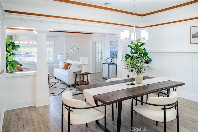 4216 Dalton Ave, Los Angeles, CA 90062 - dining space featuring a decorative wall, light wood finished floors, a wainscoted wall, and crown molding