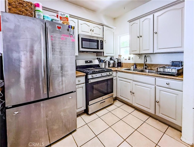 4216 Dalton Ave, Los Angeles, CA 90062 - kitchen featuring stainless steel appliances, light tile patterned flooring, and white cabinets