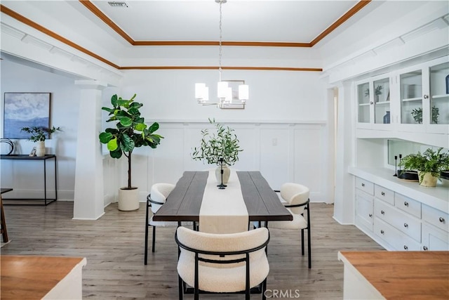 4216 Dalton Ave, Los Angeles, CA 90062 - dining space with a chandelier, light wood-type flooring, a decorative wall, wainscoting, and crown molding