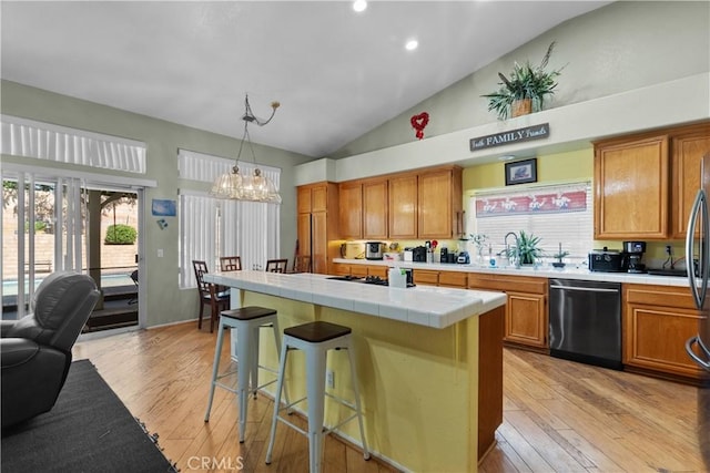 42012 57th St W, Lancaster, CA 93536 - kitchen featuring dishwashing machine, tile counters, light wood-style floors, brown cabinetry, and recessed lighting